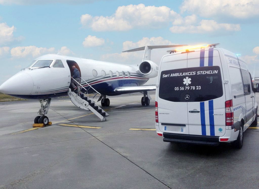 Une ambulance Stéhélin sur le tarmac de l'aéroport de Bordeaux Mérignac devant un Falcon